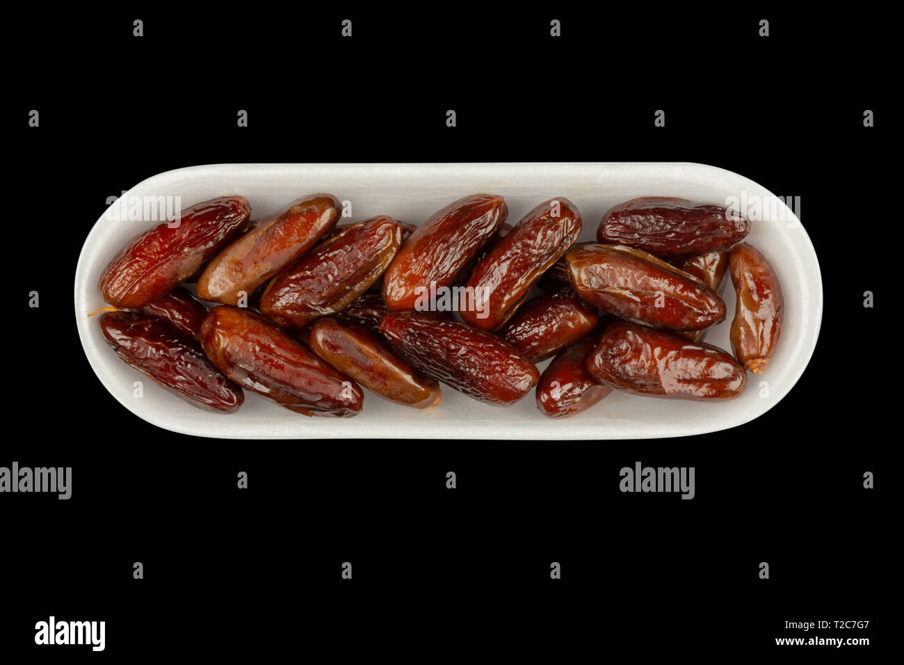 dried dates in white styrofoam packaging isolated on black background close- up, top view Stock Photo - Alamy