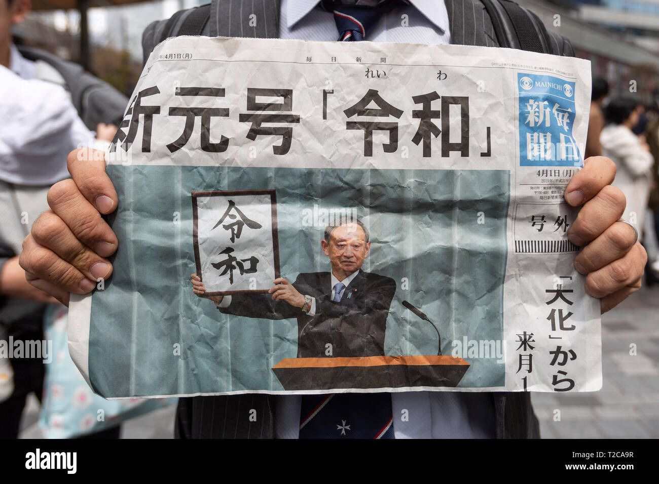 Tokyo, Japan. 1st Apr, 2019. Tokyo, Japan. 01st Apr, 2019. A man shows an  extra edition of a Japanese newspaper announcing the kanji ''Reiwa'' as the  new name of the next Imperial