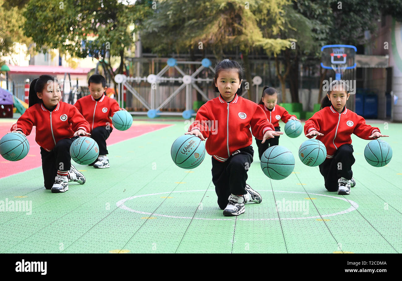 190401) -- BEIJING, April 1, 2019 (Xinhua) -- Children dribble the balls  with both hands during their outdoor exercises at Gao'an Liangshiju  Kindergarten in Yichun, east China's Jiangxi Province, on March 12,