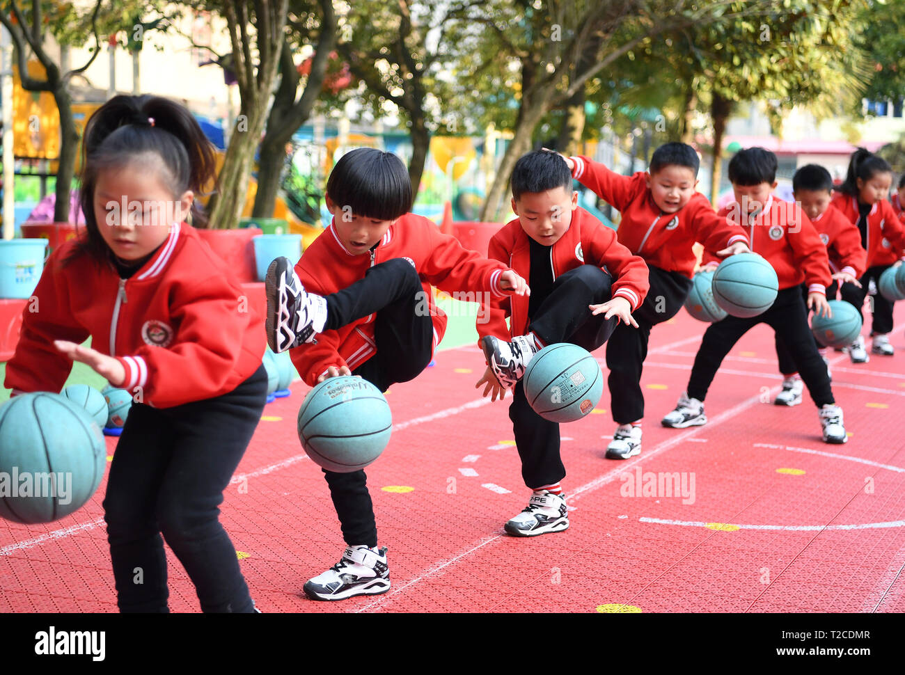 190401) -- BEIJING, April 1, 2019 (Xinhua) -- Children bounce the ball  during their outdoor exercises at Gao'an Liangshiju Kindergarten in Yichun,  east China's Jiangxi Province, on March 12, 2019. Established in