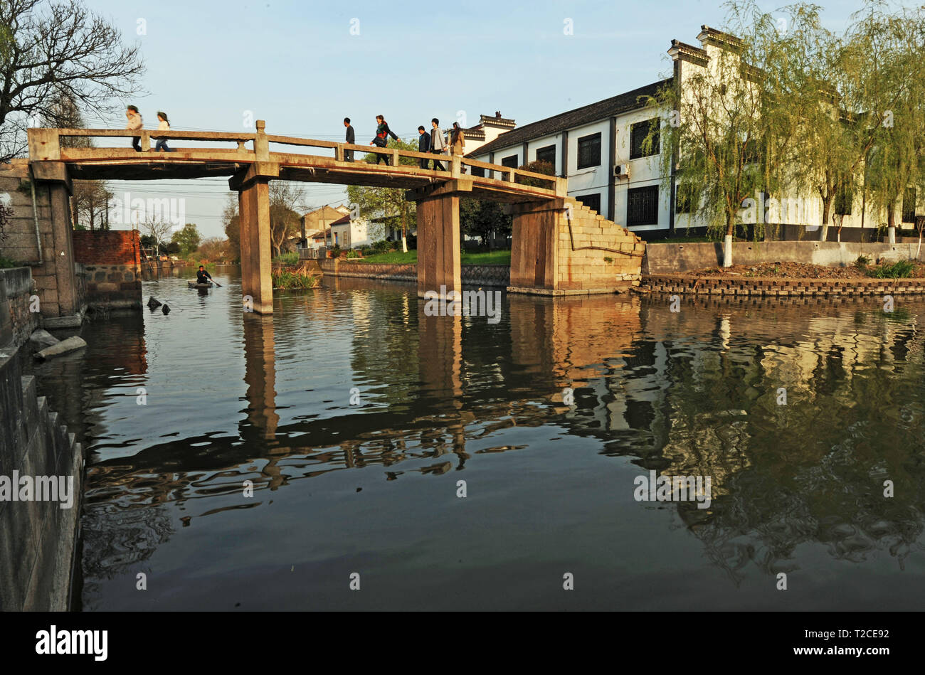Huzhou, China's Zhejiang Province. 31st Mar, 2019. People walk on a stone bridge in Jili Village of Nanxun Town in Huzhou City, east China's Zhejiang Province, March 31, 2019. The renowned historical and cultural Nanxun Town receives groups of tourists in the spring. Located on the south bank of Nanhu Lake, Nanxun Town is famous for natural scenery and garden landscape. Credit: Tan Jin/Xinhua/Alamy Live News Stock Photo