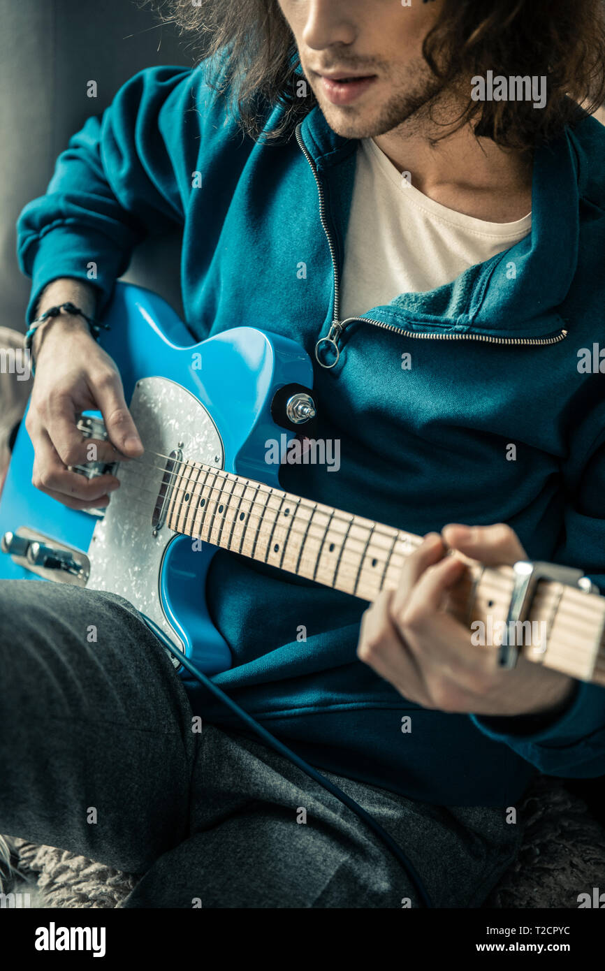 Long-haired man with black stubble wearing blue sweatshirt Stock Photo