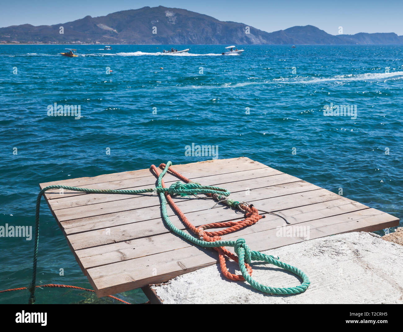 Colorful nautical ropes lay on wooden pier. Zakynthos island, Greece Stock Photo