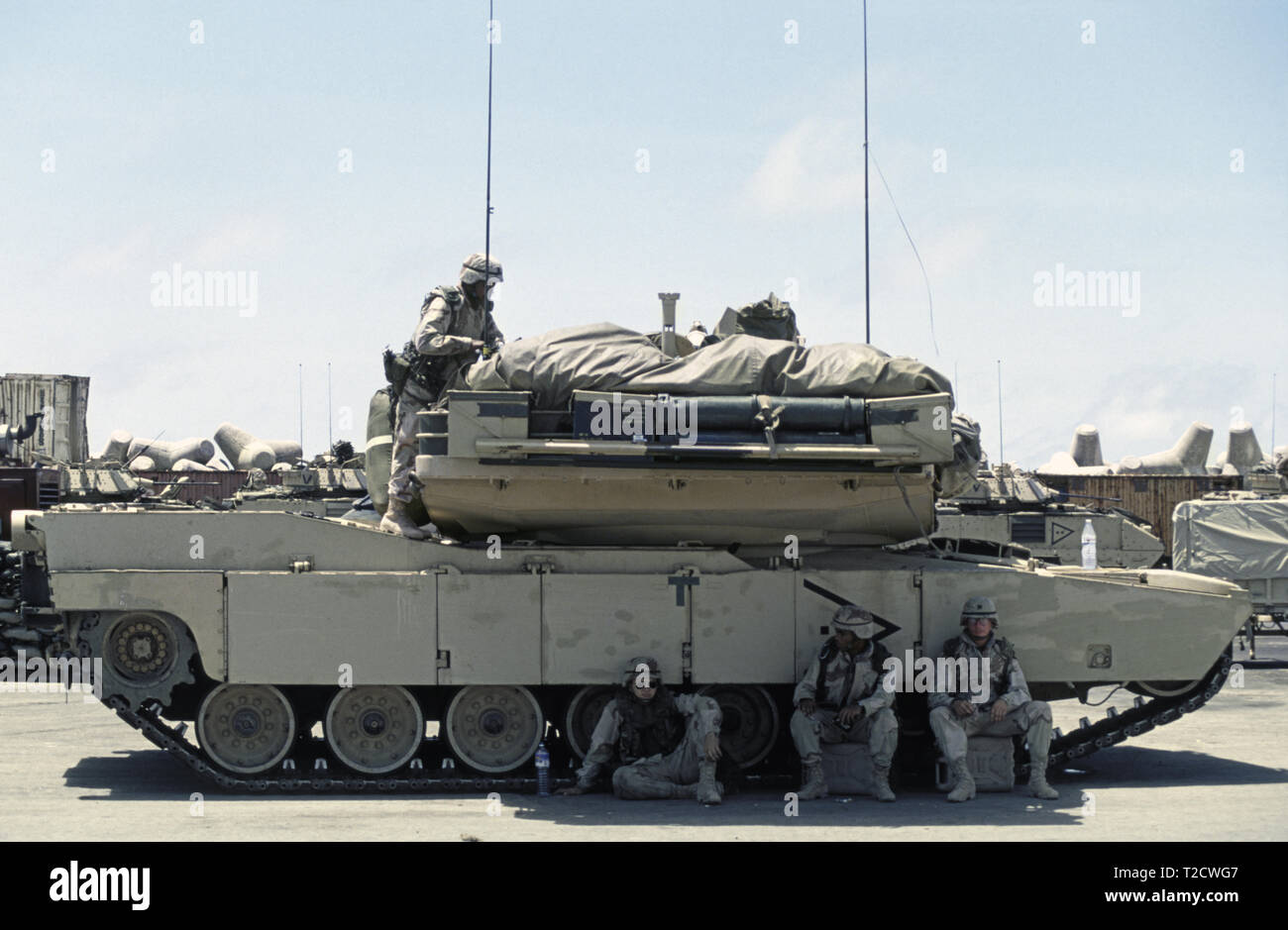 30th October 1993 U.S. Army soldiers shelter from the fierce heat in the shade of their M1A1 Abrams tank of the 24th Infantry Division, 1st Battalion of the 64th Armored Regiment. They have just arrived in the new port in Mogadishu, Somalia. Stock Photo