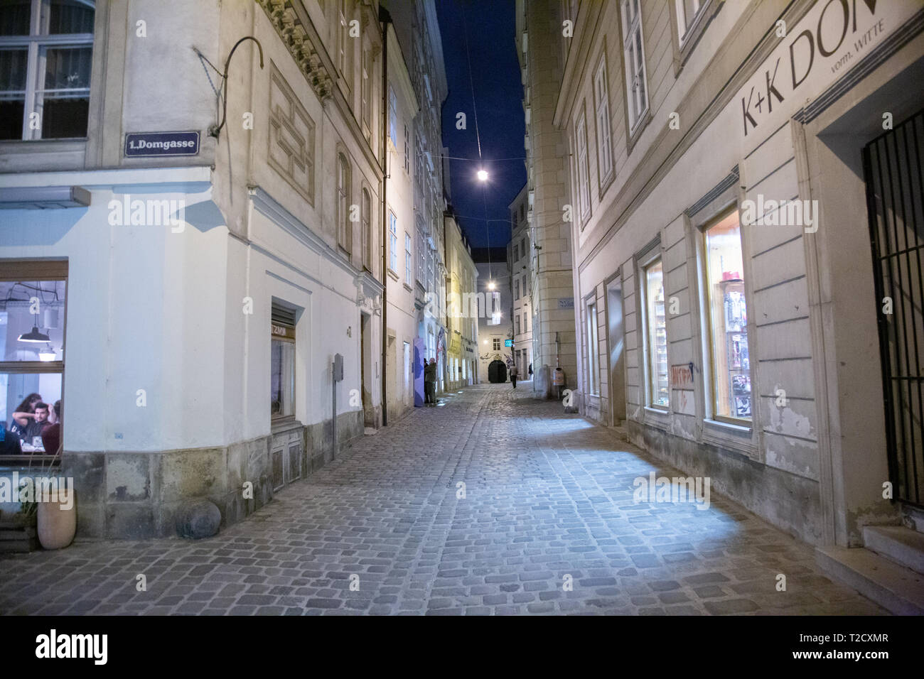 Domgasse, Vienna at Night. View from the West to the East end of the street, including a street sign and the Mozart House with people outside Stock Photo