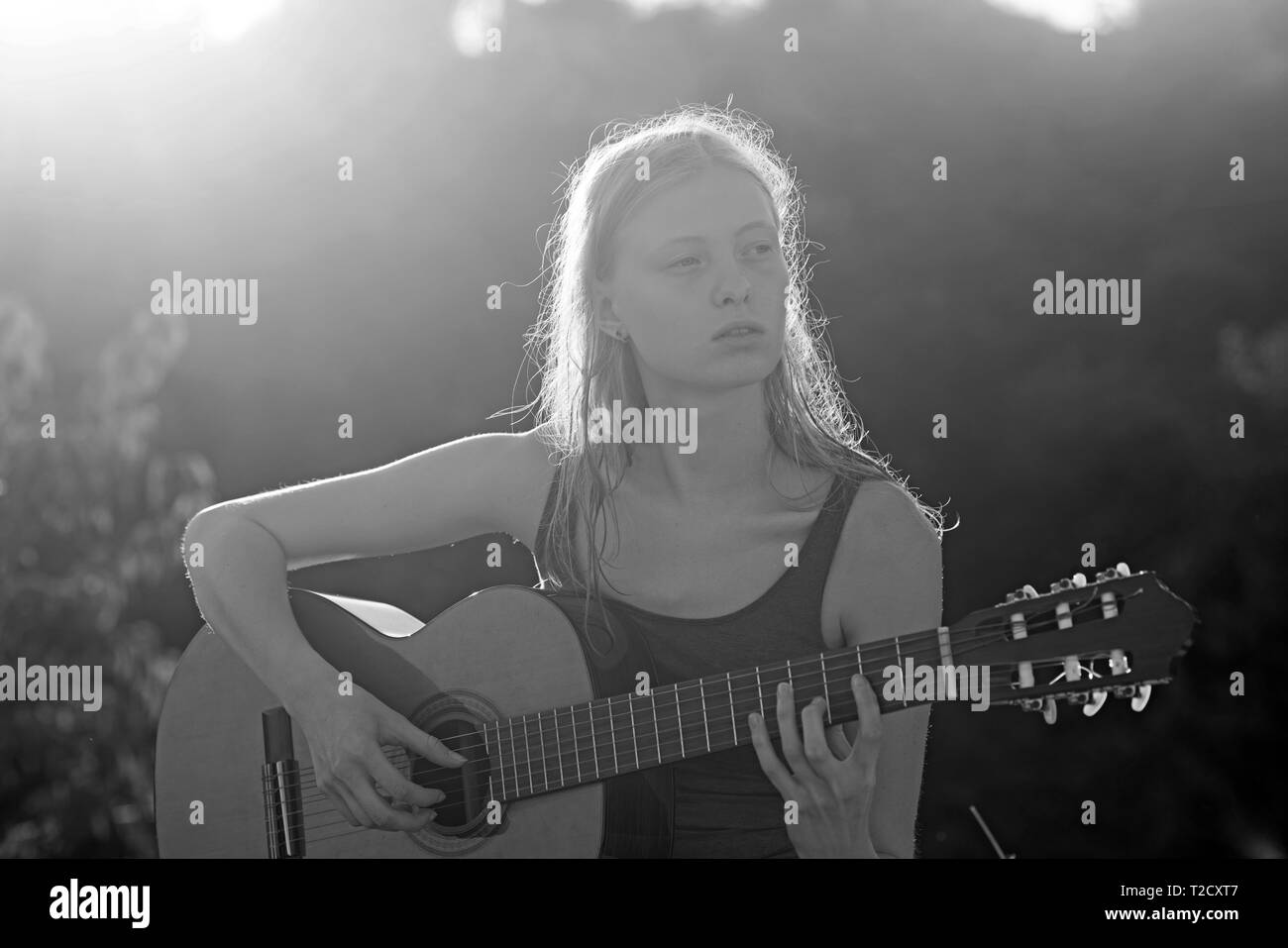 Beautiful young girl playing guitar outdoor in summer Stock Photo - Alamy