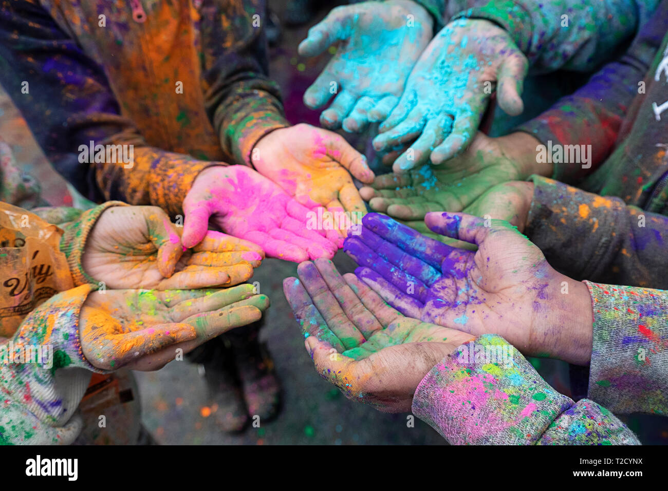 Children's hands at the Holi Parade on Liberty Ave in Richmond Hill, Queens, New York where it's customary to throw & smear colored powder. Stock Photo