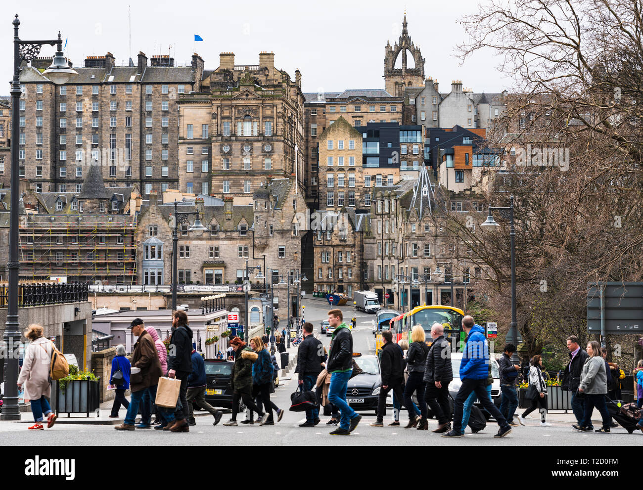 Pedestrians crossing street with Old Town to rear in central Edinburgh, Scotland, UK Stock Photo