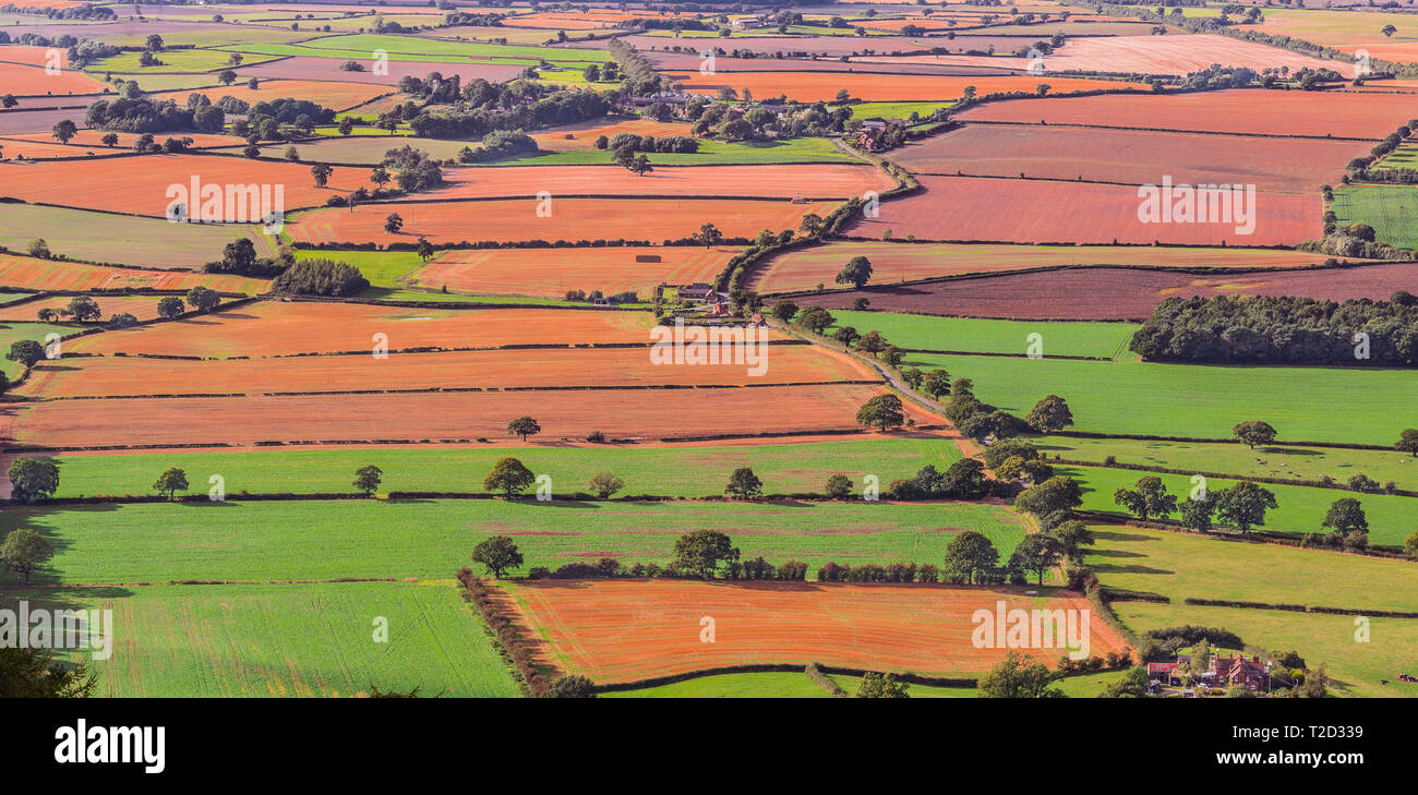 Rural landscape with green and red fields - Concept of living in the countryside of England, peaceful life outside urban areas. Stock Photo