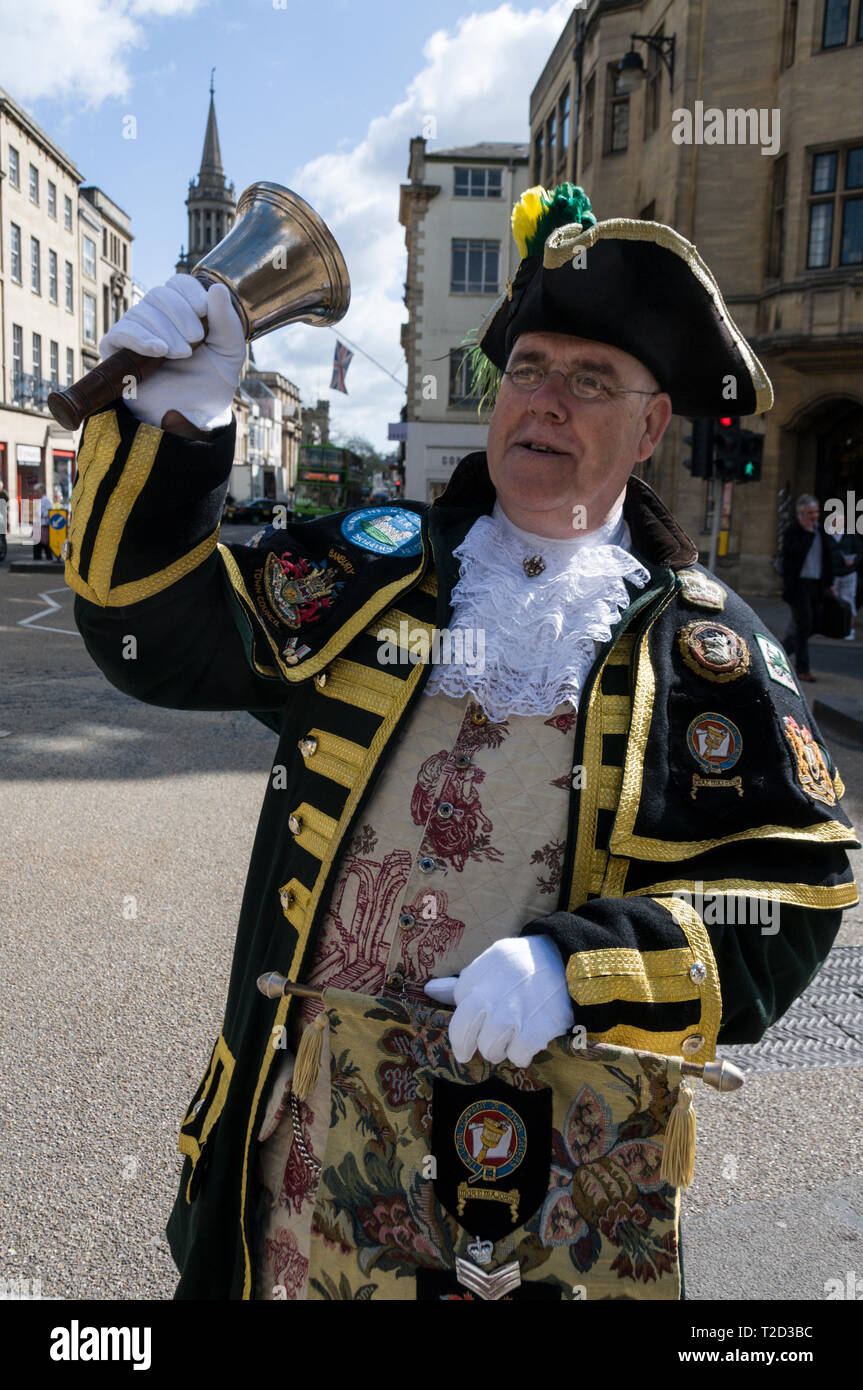 The Town Crier for Oxford and surrounding towns in Oxfordshire, ringing his bell in Oxford, Britain.  The town crier used to make public announcements Stock Photo