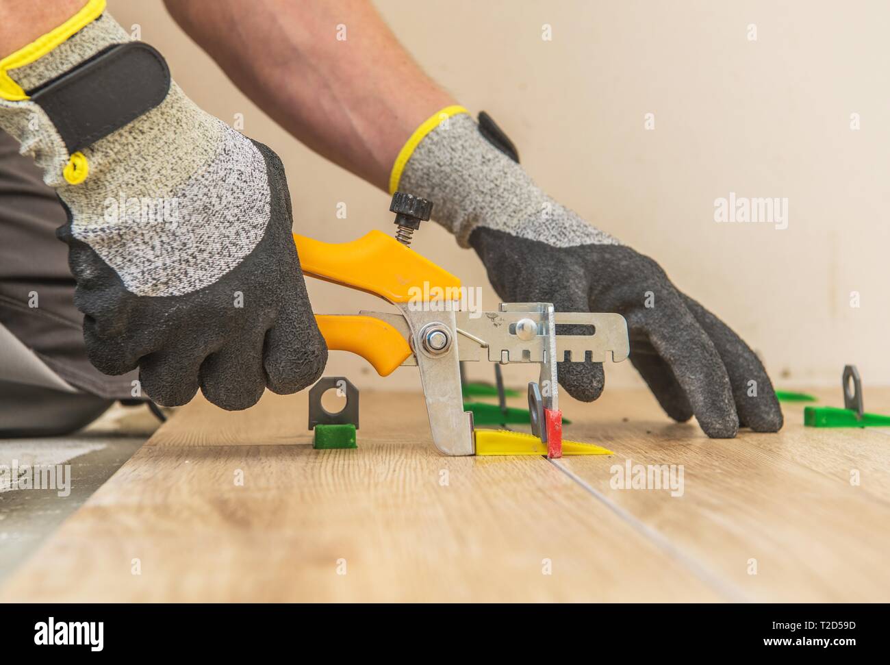 Ceramic Tiles Leveling System. Worker Installing Leveling Separators