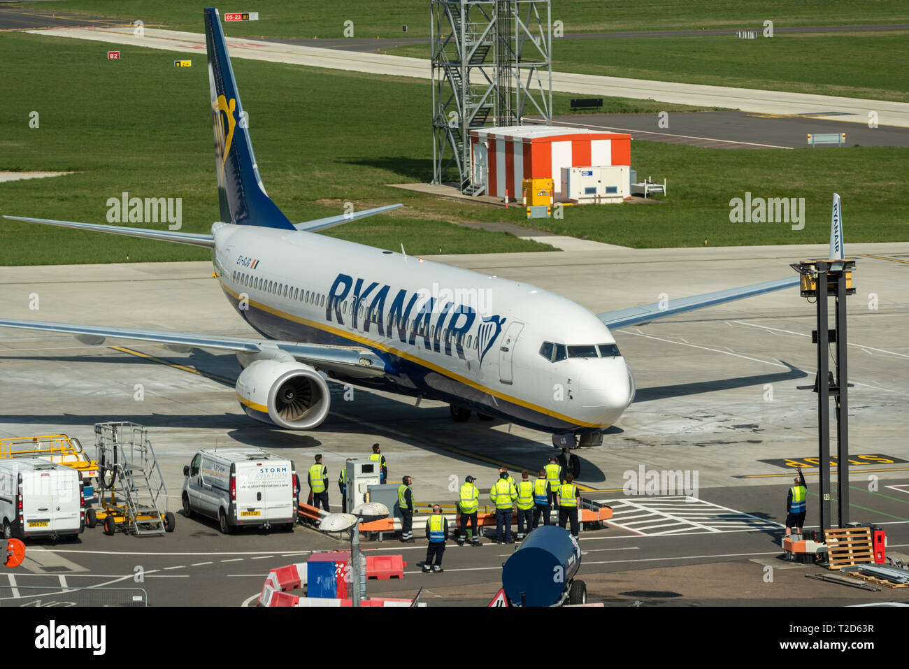 First Ryanair Boeing 737 EI-GJG arriving at parking spot at London Southend Airport, Essex, UK, with waiting ground handlers. New service. New routes Stock Photo