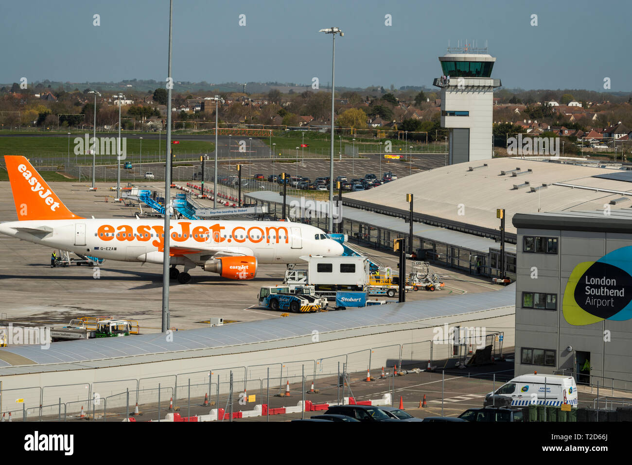 London Southend Airport, Essex, UK, passenger terminal and air traffic control tower with easyJet Airbus on ramp apron and various ground equipment Stock Photo