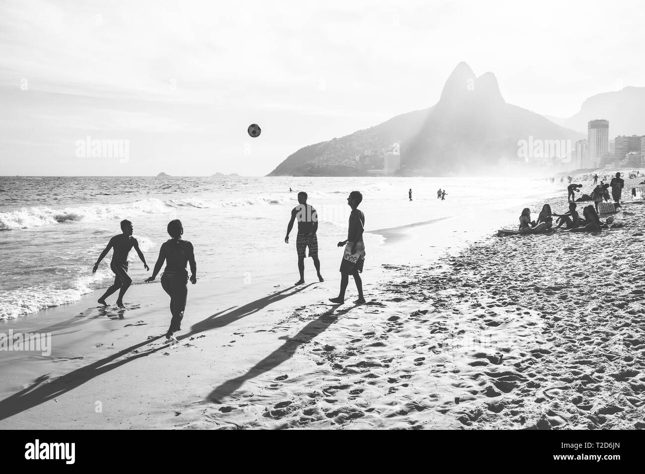 RIO DE JANEIRO, BRAZIL - FEBRUARY 24, 2015: A group of Brazilians playing on the shore of Ipanema Beach Stock Photo
