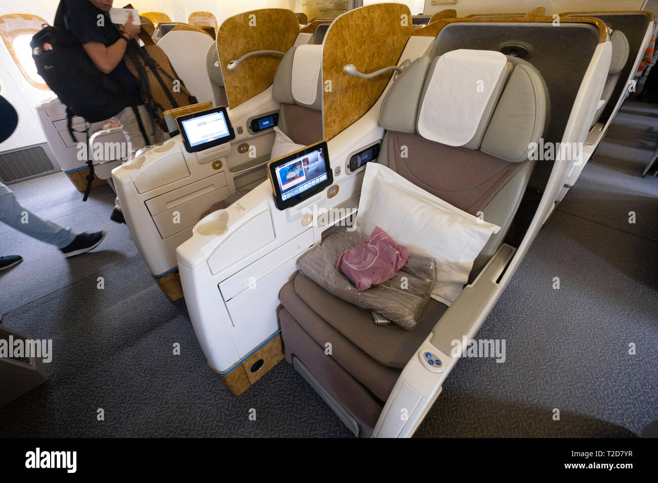 Spacious business class empty seats with pillows on a Emirates commercial flight airplane Stock Photo