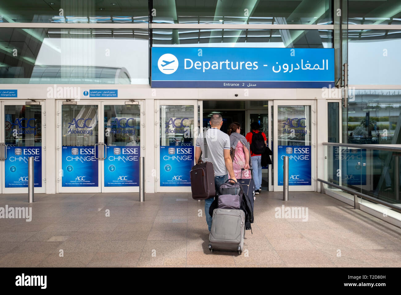 Passengers with rolling cases entering the departures terminal at the Dubai International Airport in United Arab Emirates Stock Photo