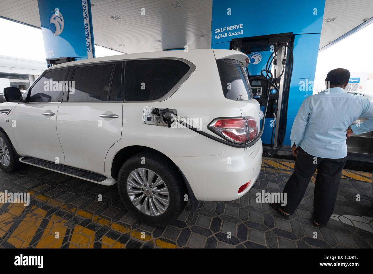 Man filling his SUV fuel tank at a petrol station in Dubai, United Arab Emirates Stock Photo