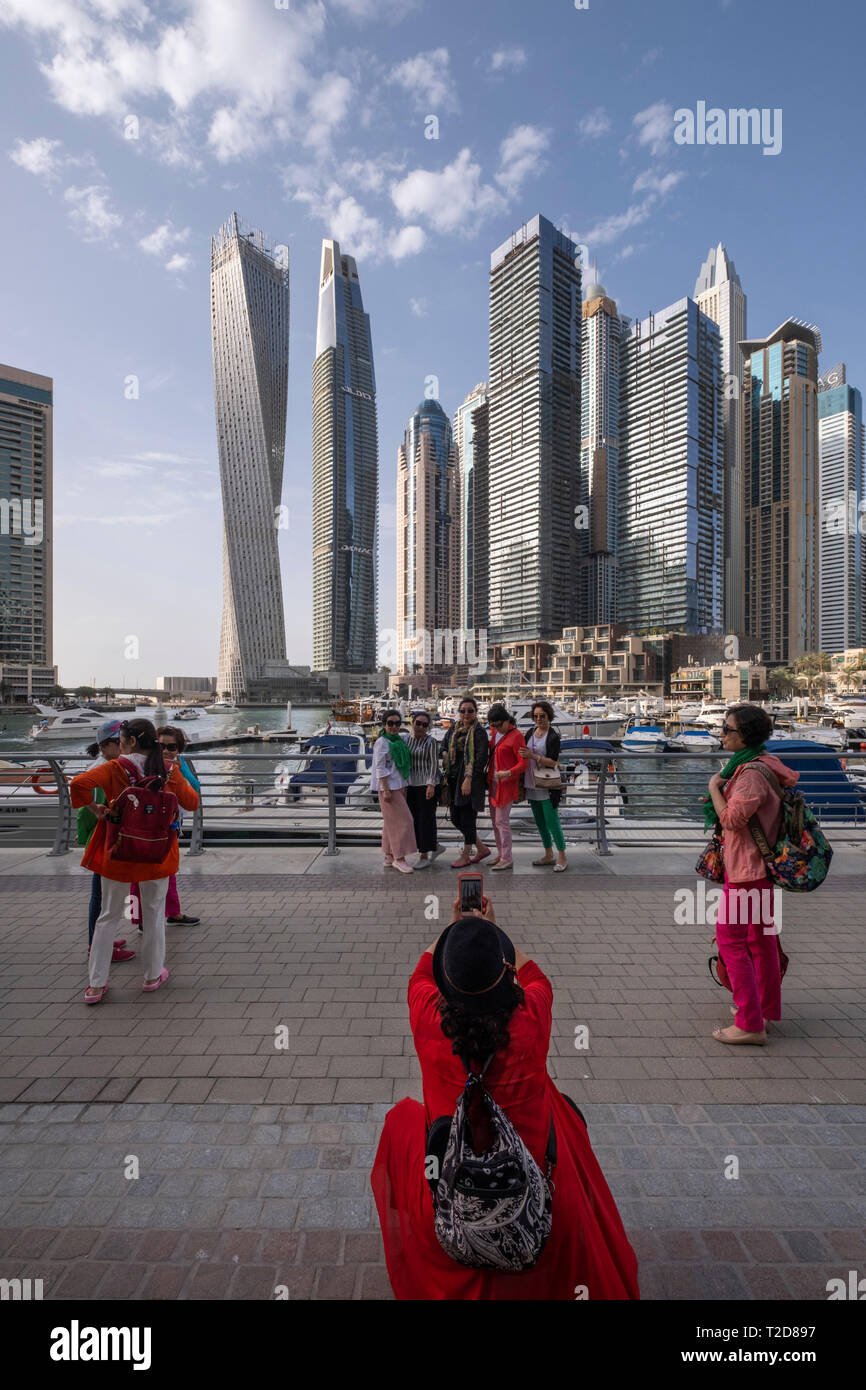 Asian tourists posing for photographs at the Dubai Marina, Dubai, United Arab Emirates Stock Photo