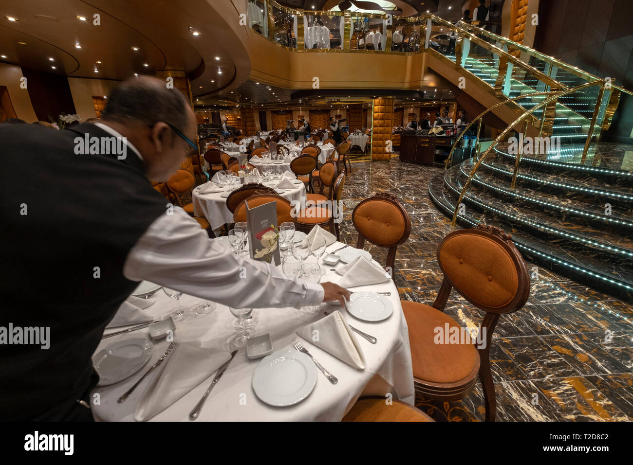 Waiter setting the table at a upscale luxurious restaurant Stock Photo