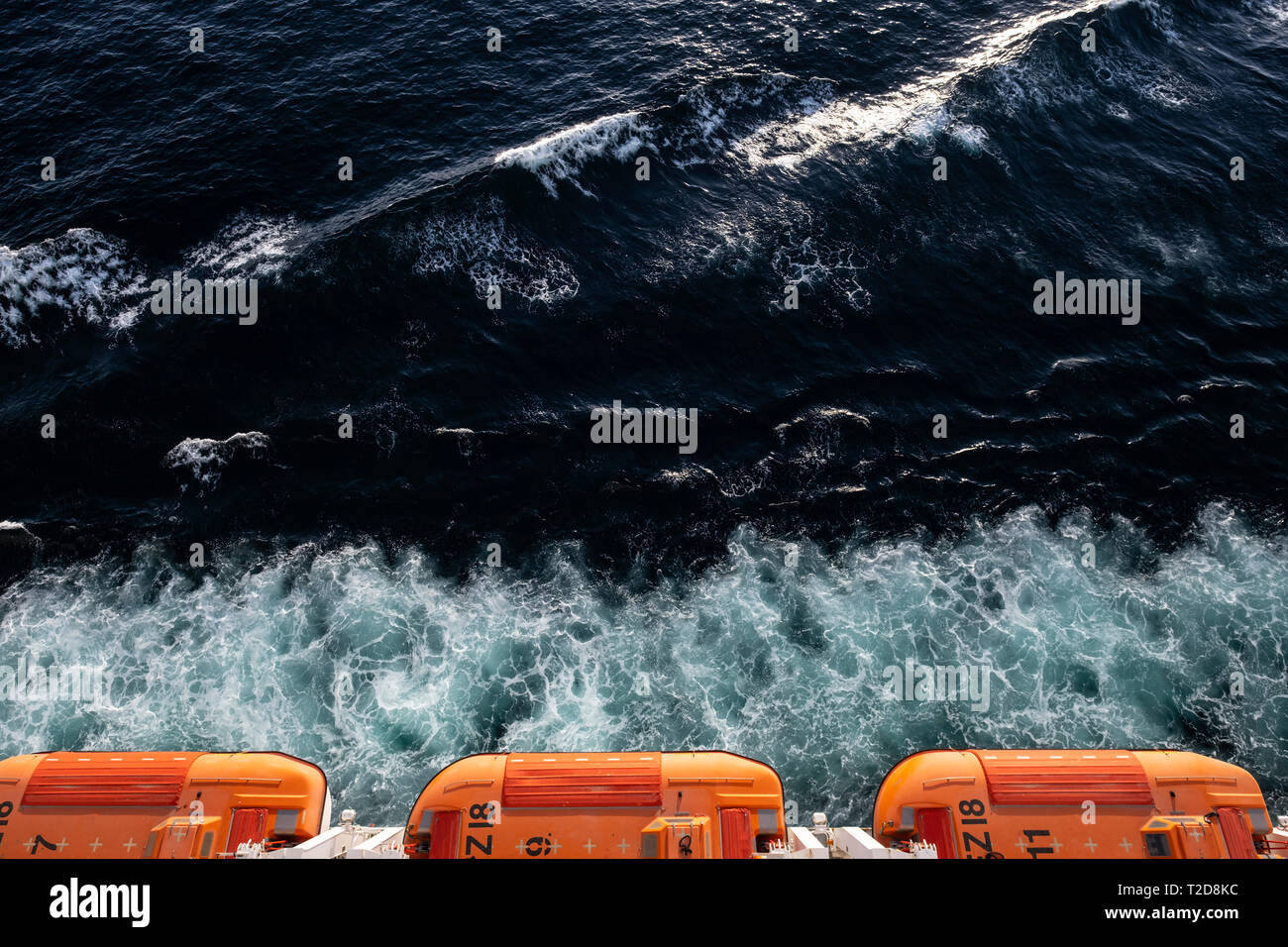 Overhead view of three orange lifeboats hanging from the cruise ship MSC Splendida at sea Stock Photo