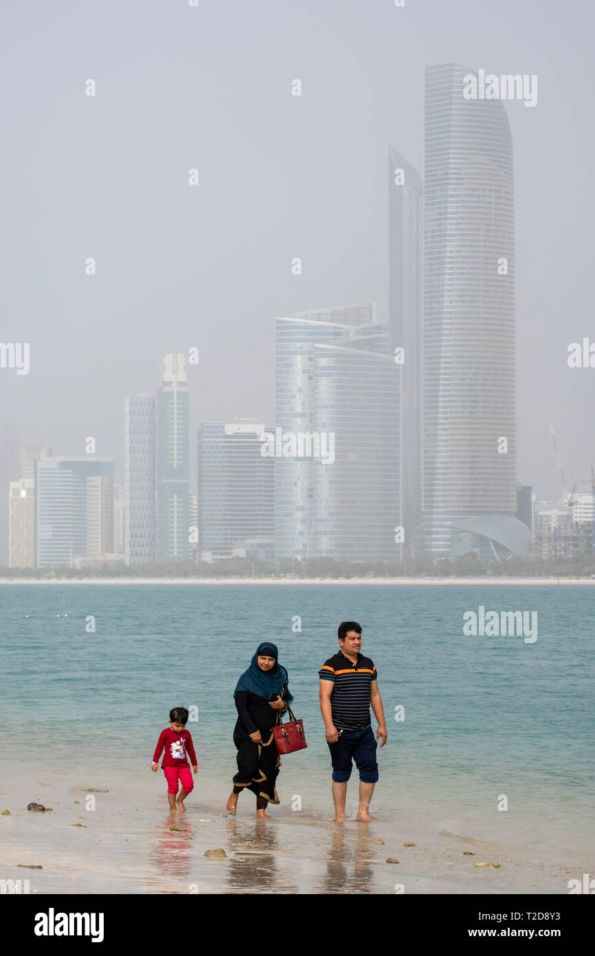 Muslim family walking at a beach in Abu Dhabi, United Arab Emirates Stock Photo