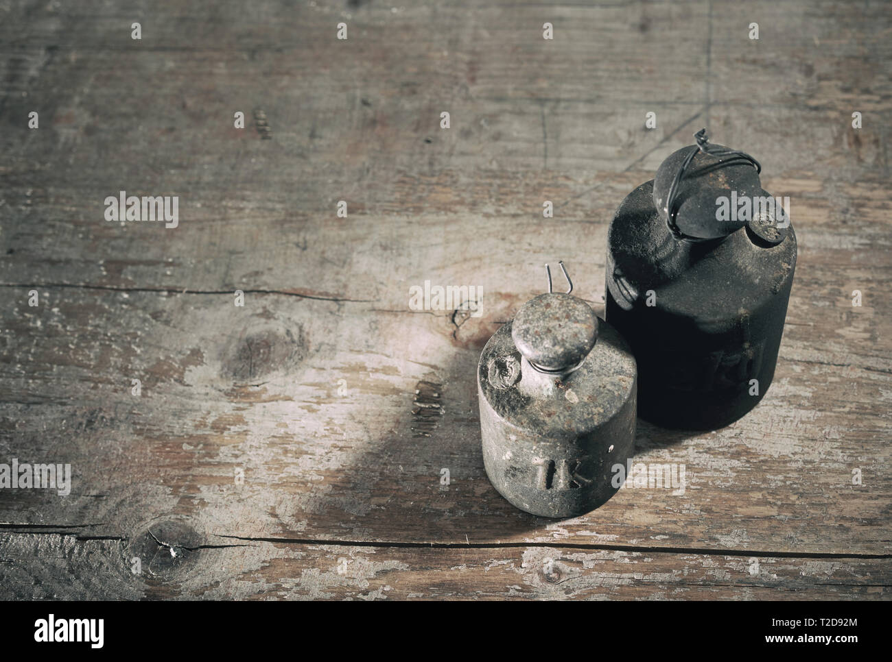 Two old dirty weights or measures for manual weighing on a scale on a ...