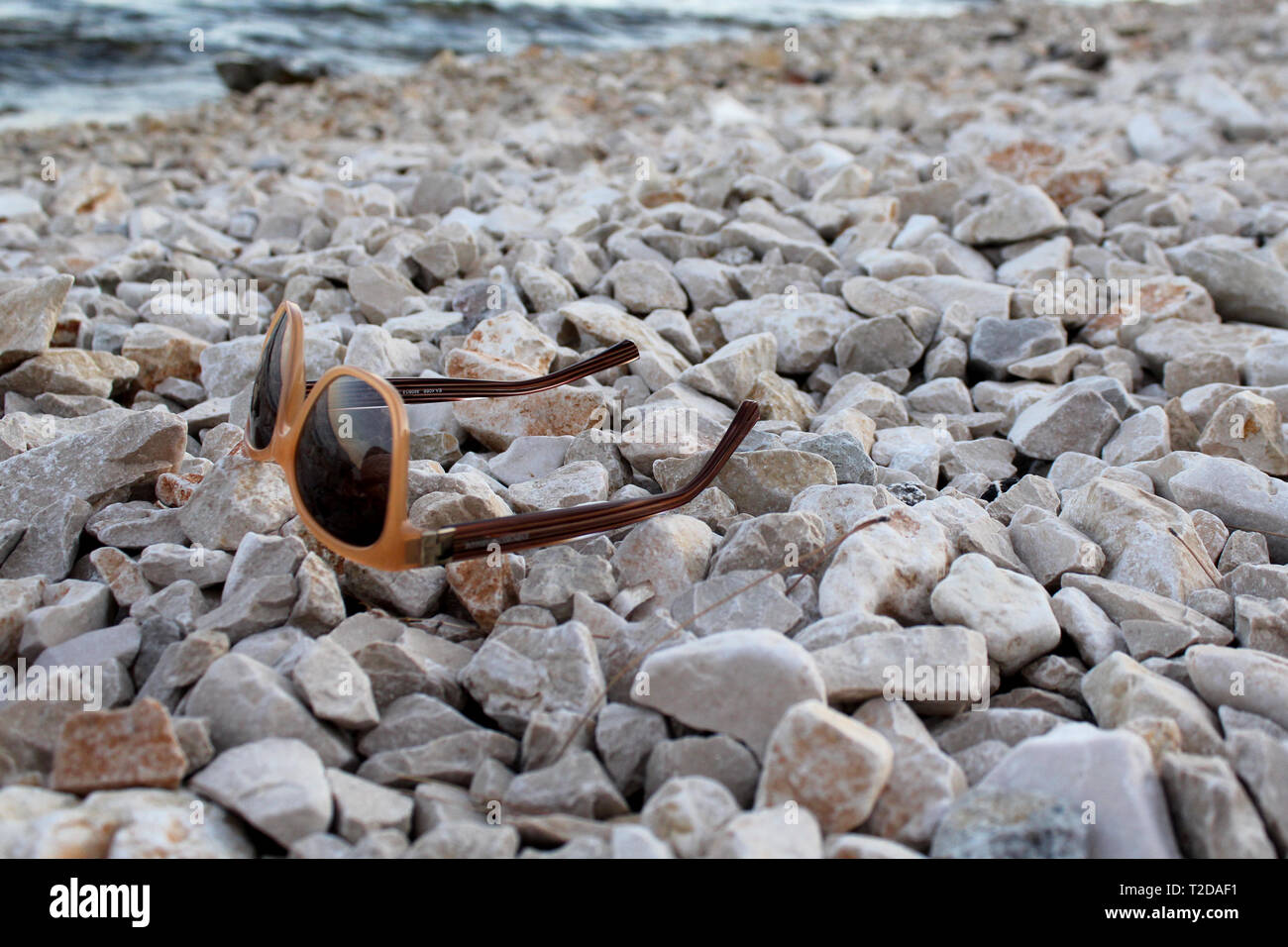 Sunglasses on a stone beach in Vir, Croatia Stock Photo