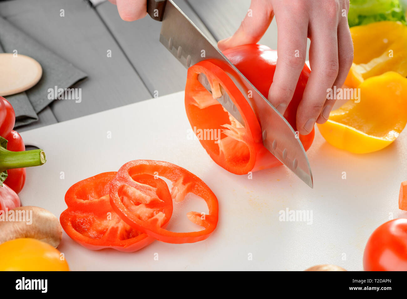 https://c8.alamy.com/comp/T2DAPN/cutting-bell-pepper-into-rings-men-using-a-sharp-santoku-knife-for-perfect-cut-cooking-vegetables-vegetarian-recipe-T2DAPN.jpg