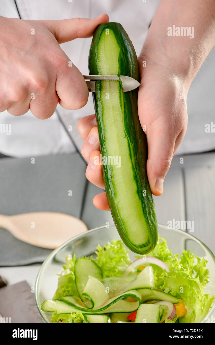 https://c8.alamy.com/comp/T2DB6X/man-cutting-a-cucumber-into-ribbons-with-a-peeler-knife-chef-cooking-a-vegetable-salad-T2DB6X.jpg