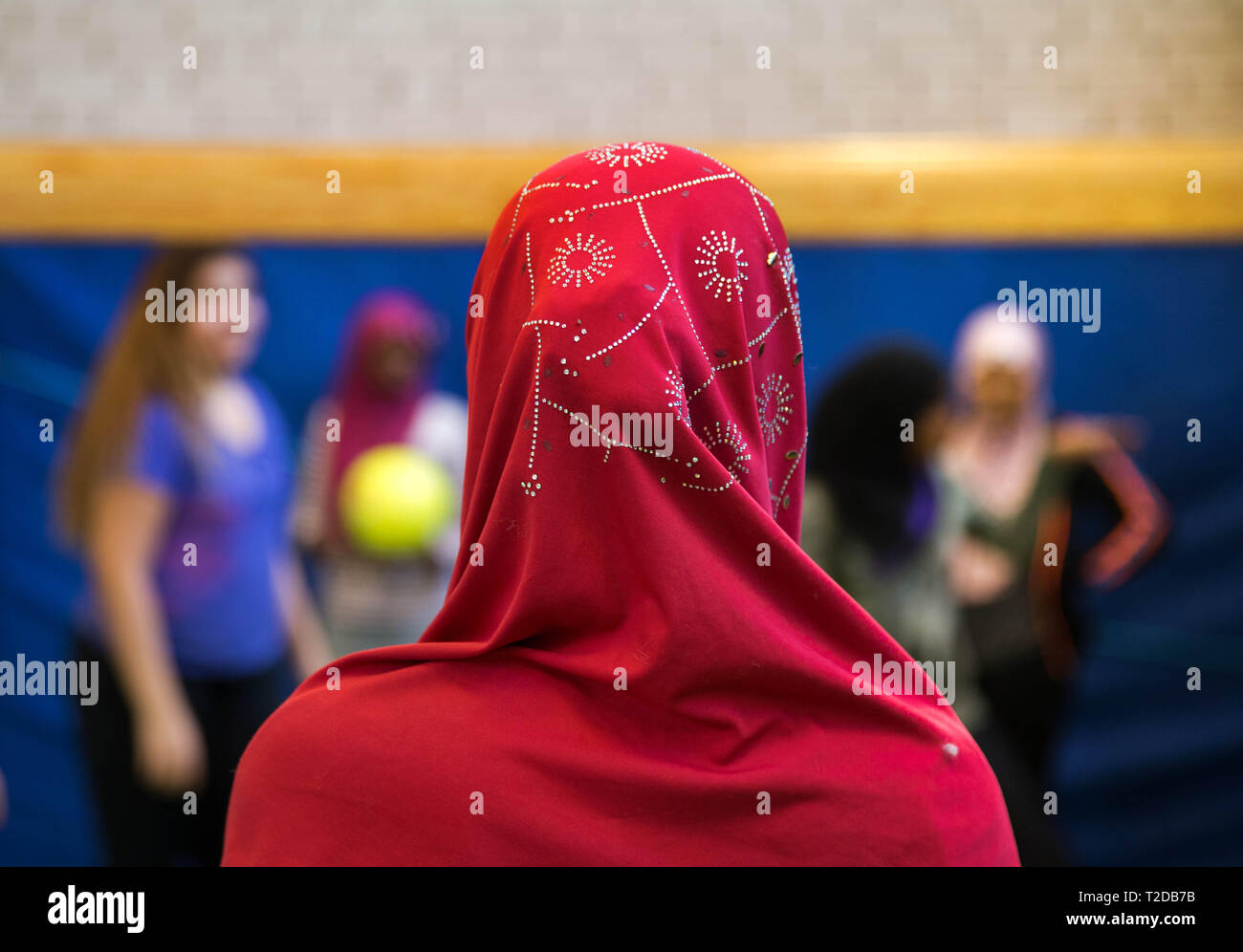 Girl with veil during a sports lesson in a school. Stock Photo