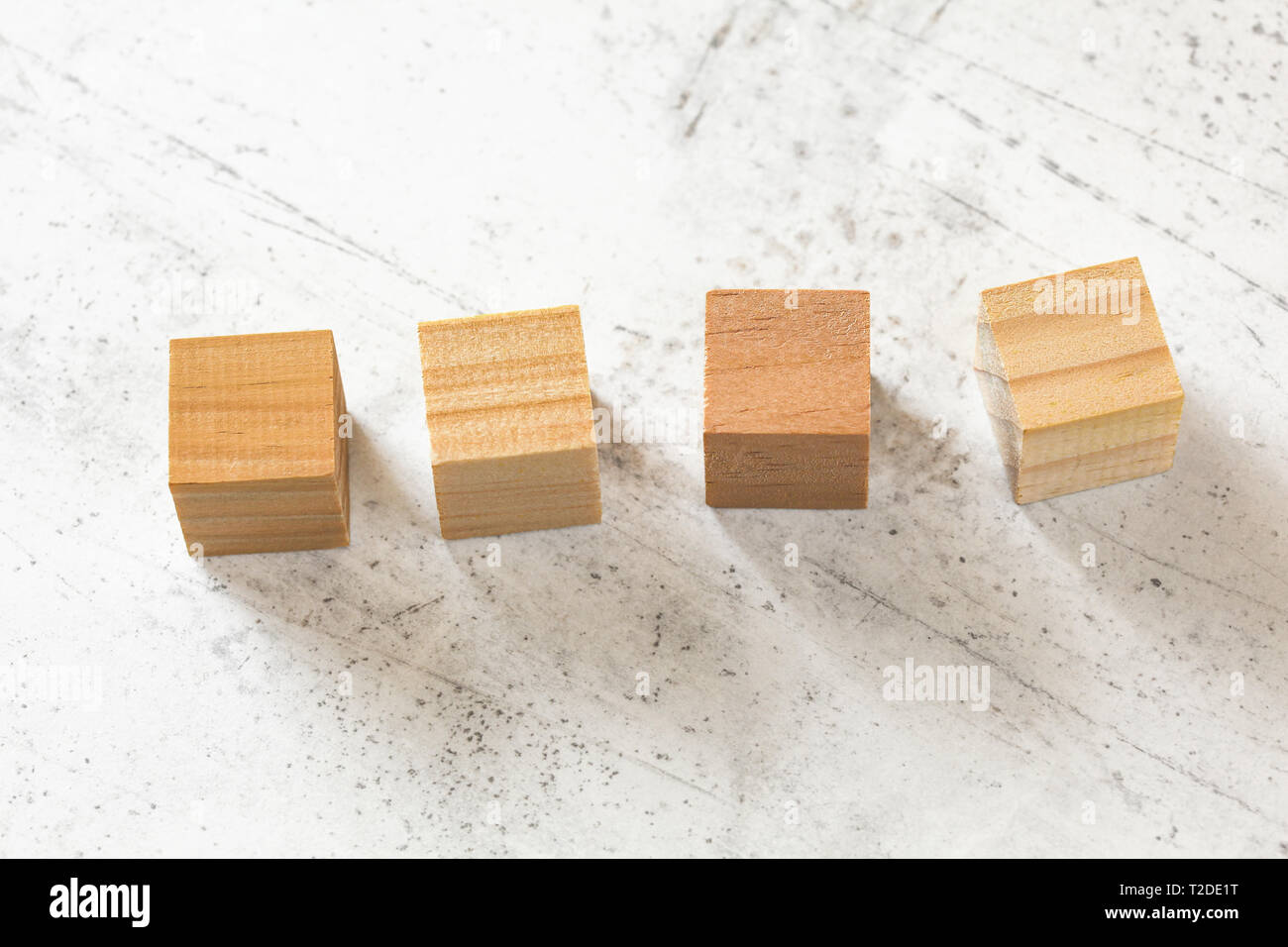 Four blank wooden cubes on white cement board Stock Photo Alamy
