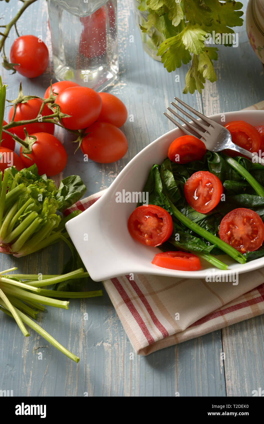 boiled spinach with cherry tomato - closeup Stock Photo
