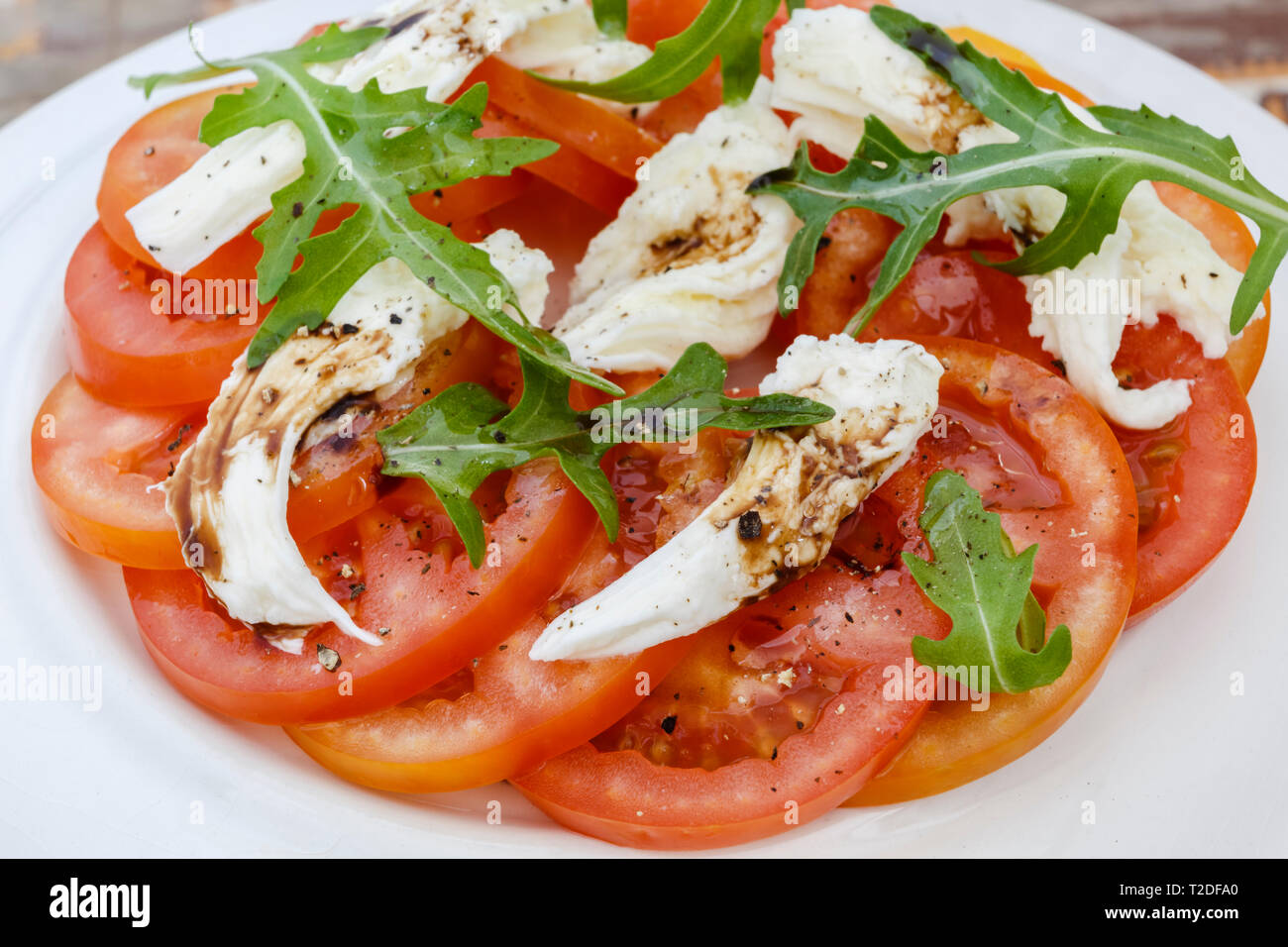 Slice Tomato Salad With Mozzarella And Rocket Leaves With A Balsamic Vinegar And Olive Oil Dressing Stock Photo Alamy