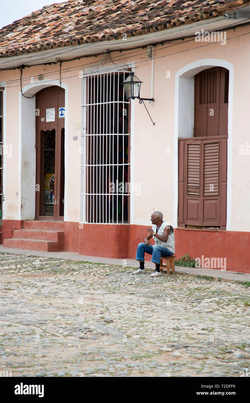 Local Cuban sitting outside an old building in Trinidad,Cuba Stock Photo