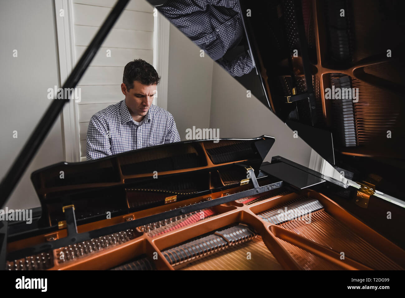 Close up of a man playing baby grand piano Stock Photo