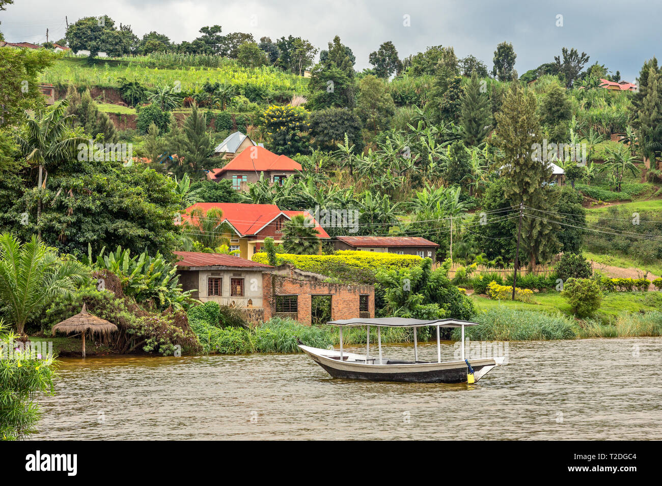 Roof boat anchored at the coast with rwandan village in the background ...