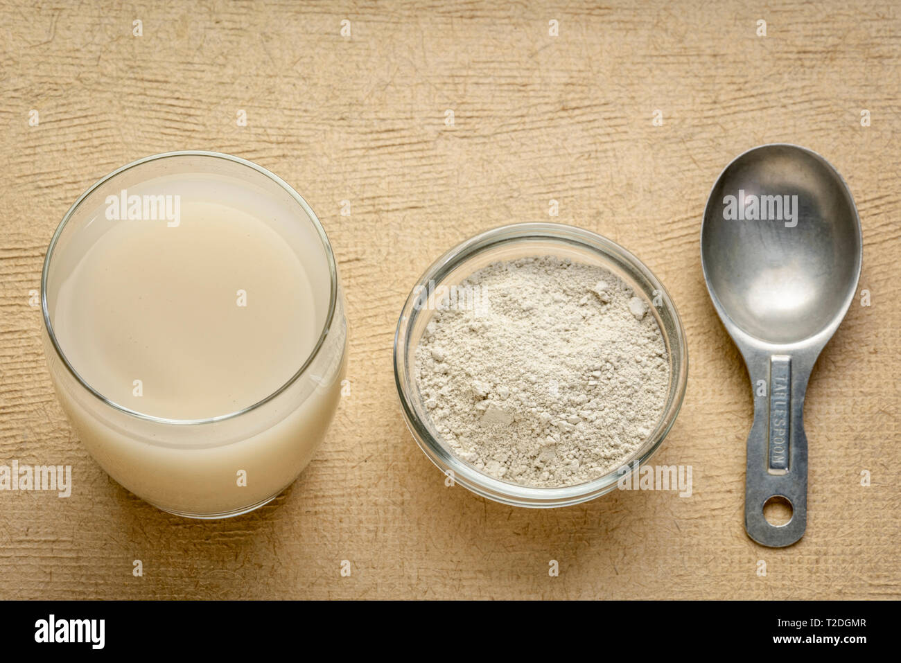 food grade diatomaceous earth supplement - powder and in a glass of water  with measuring scoop Stock Photo