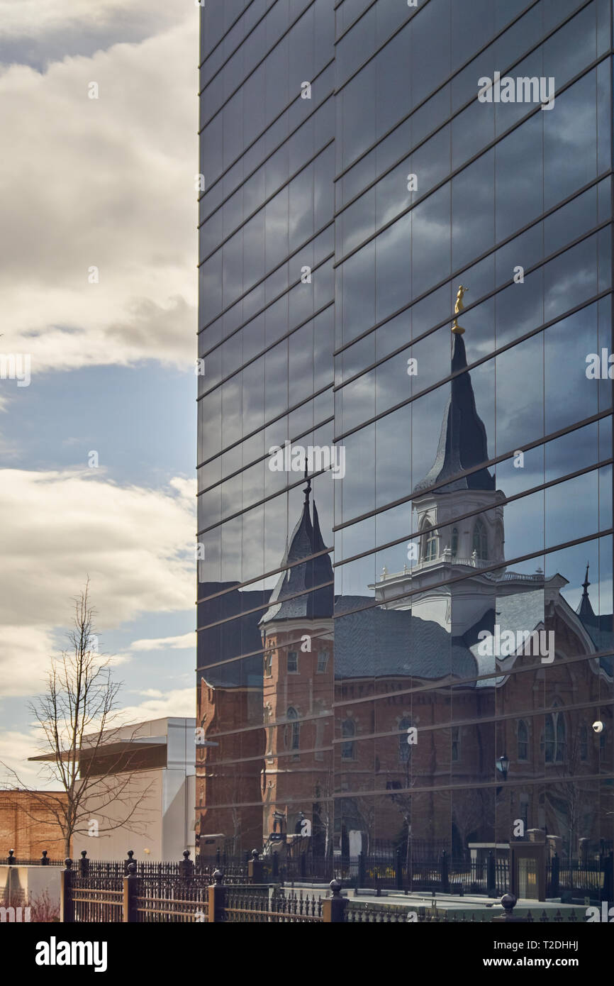 The Provo City Center temple of the Church of Jesus Christ of Latter-day Saints is reflected in the Nu Skin Enterprises building's glass windows. Stock Photo