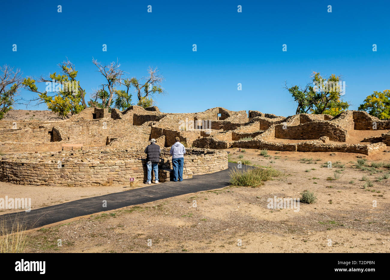 Senior tourists look into an ancestral pueblo kiva at Aztec Ruins National Monument, New Mexico USA Stock Photo