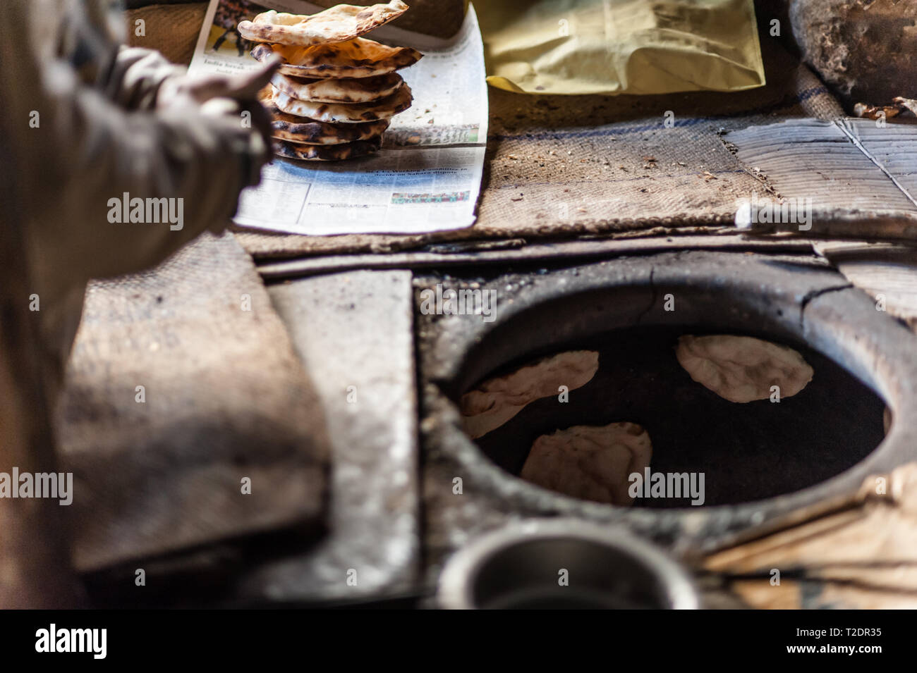 Freshly cooked bread from the tan door oven, in the cold, early morning light. Leh, Ladakh, India. Stock Photo