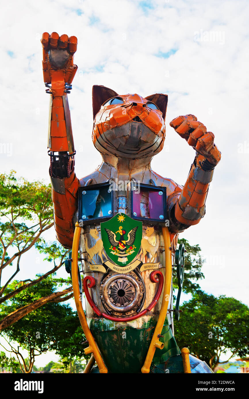 Kuching, Malaysia - March 11, 2019: Funny metal cat statue with Kuching city coat of arms at waterfront of Sarawak river. Cat is a symbol of Kuching Stock Photo