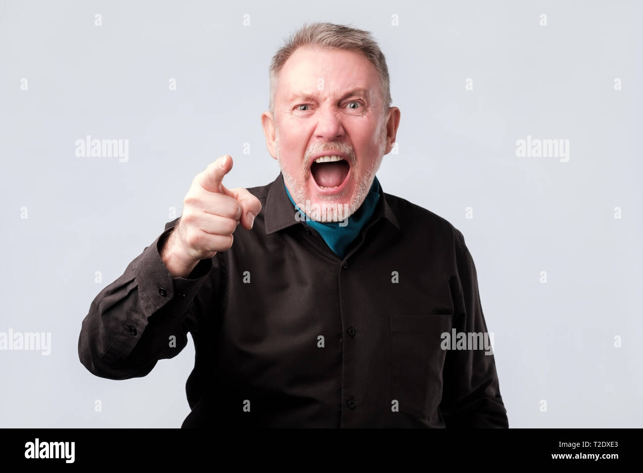 Angry man screaming, pointing his index finger directly at you. Father accuses child of doing the wrong thing. negative facial emotion. Stock Photo