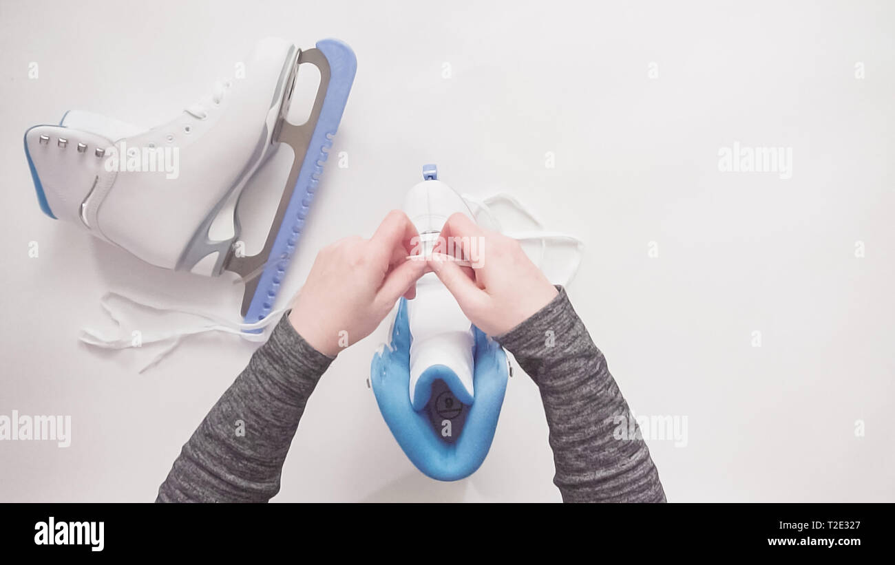 Flat lay. Lacing new white figure skates with white laces Stock Photo