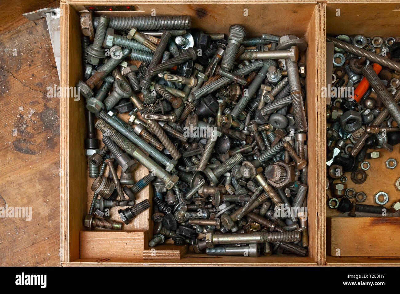 Wooden box with a bunch of nuts, bolts and screws. Tools and fasteners