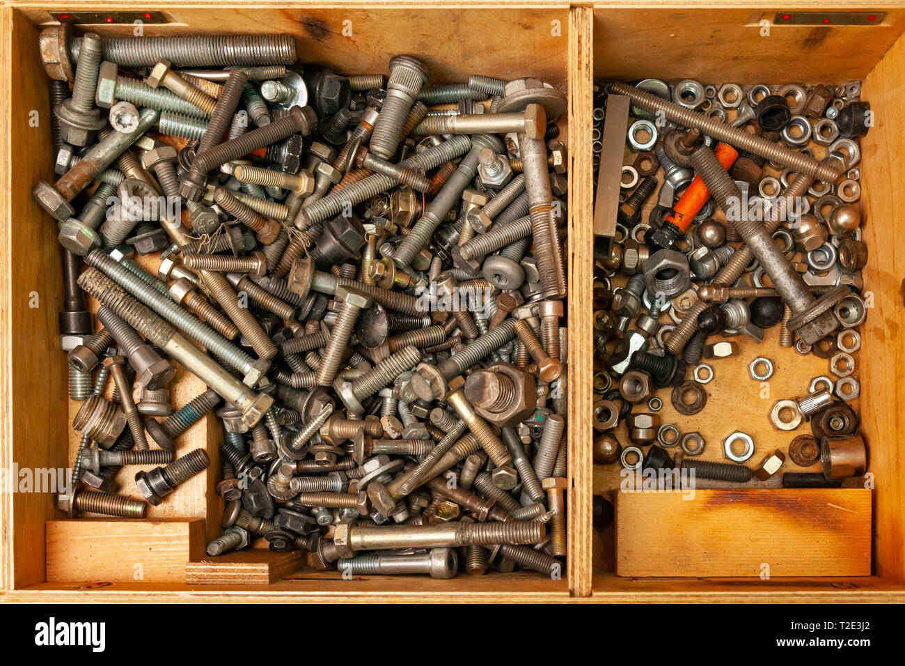 Wooden box with a bunch of nuts, bolts and screws. Tools and fasteners