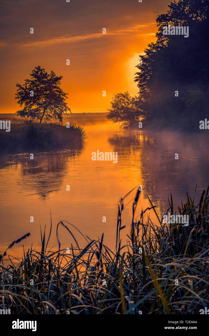 Beautiful morning on a river meander in a natural landscape with lot of fog and steam at sunrise Stock Photo