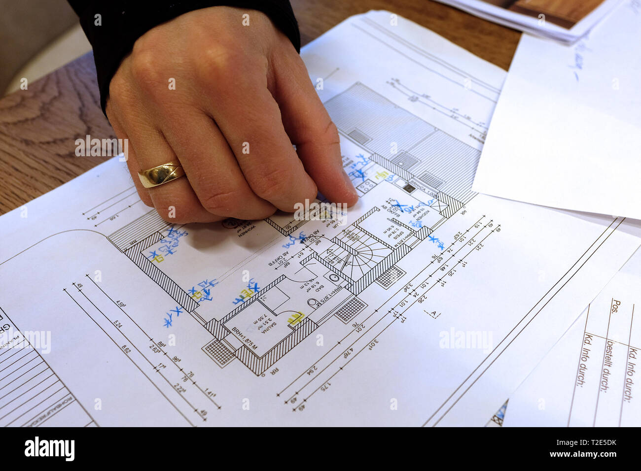 Architect, engineer discussing blueprint of a house with its clients in the office Stock Photo