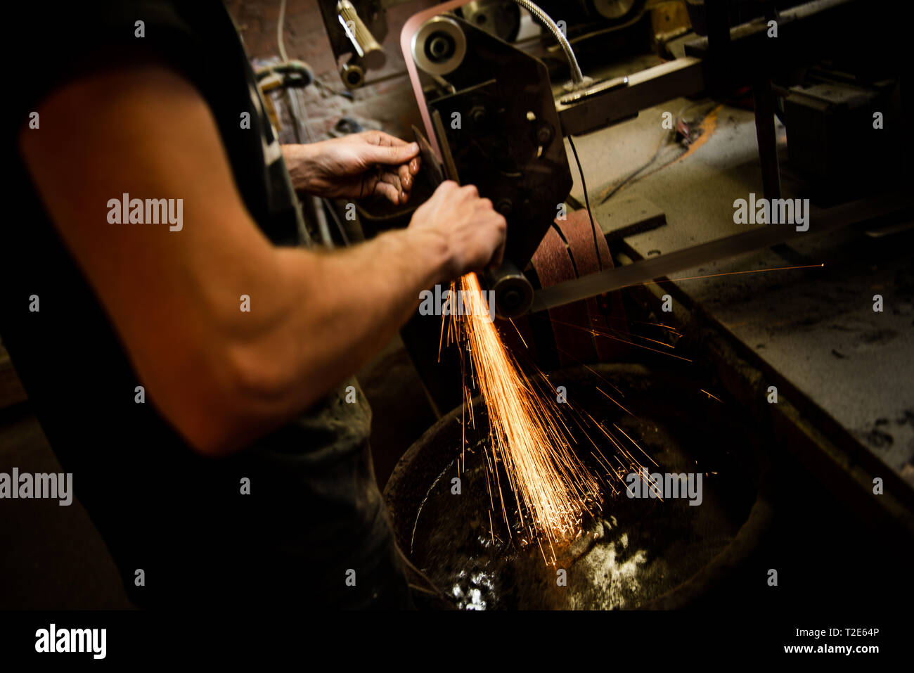 Sharpening knife on grinder grinding on bench grinder using making sharp  for easy cutting UK England GB (release available Stock Photo - Alamy