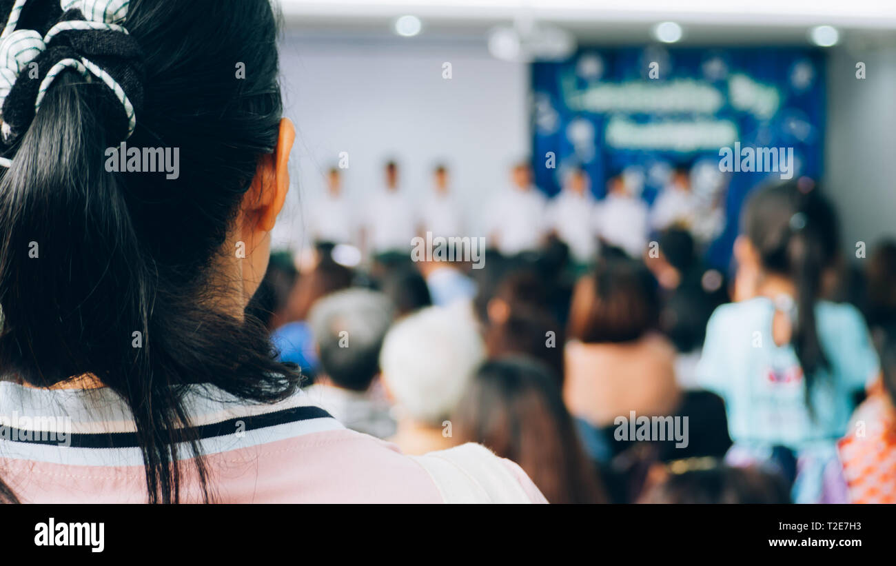 The parent listening and watching student on stage in convention hall. Stock Photo