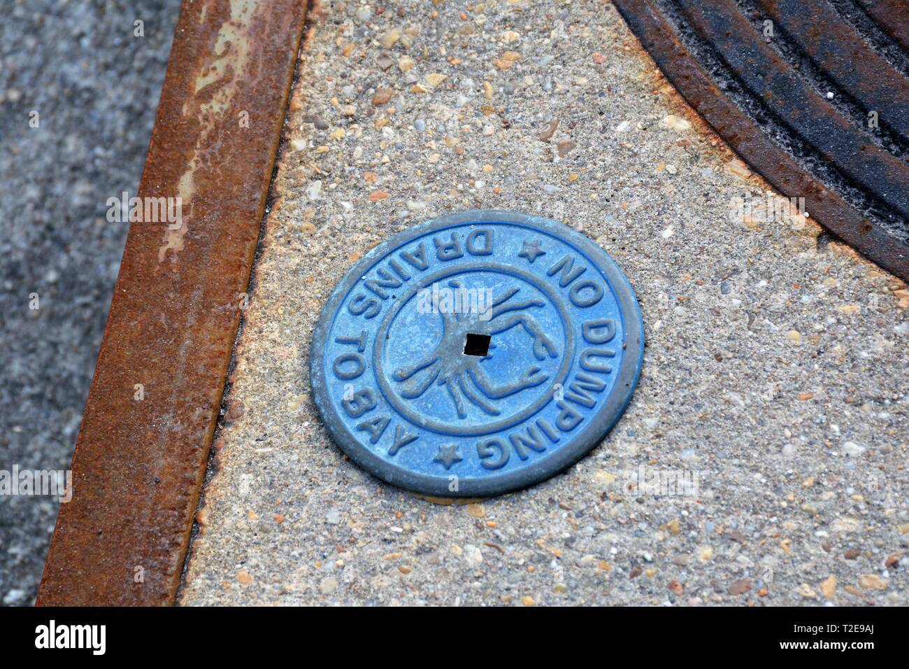 sign next to drain cover which leads from street to the ocean, the Atlantic in Annapolis Maryland Stock Photo